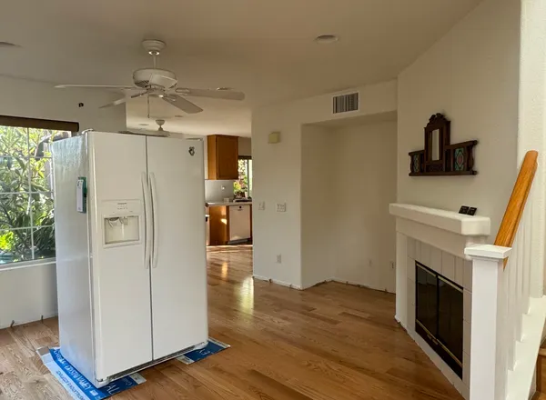Finished wood-tone floor and kitchen
