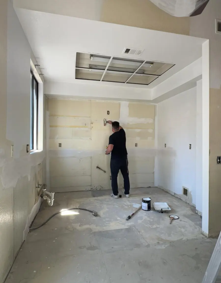 Wix Solutions team member preparing interior walls for a painting project