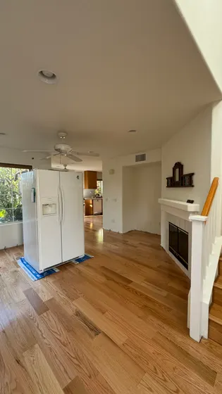 Finished wood-tone floor and kitchen