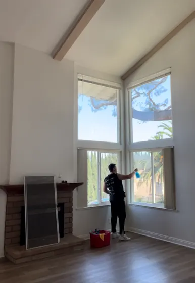 Team member cleaning tall interior windows