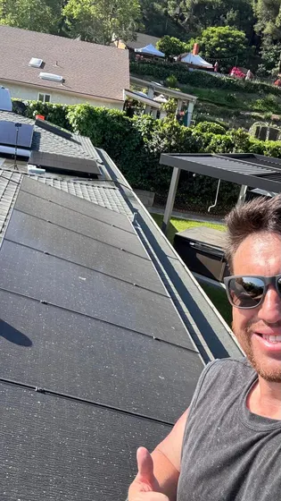 Person working beside rooftop panels