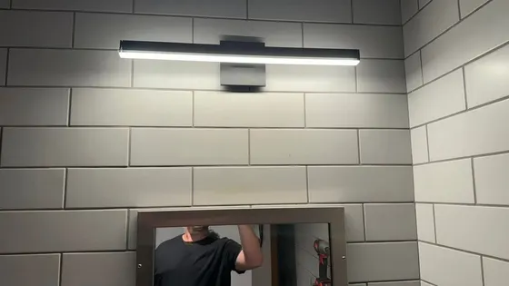 A man is looking at himself in a bathroom mirror.