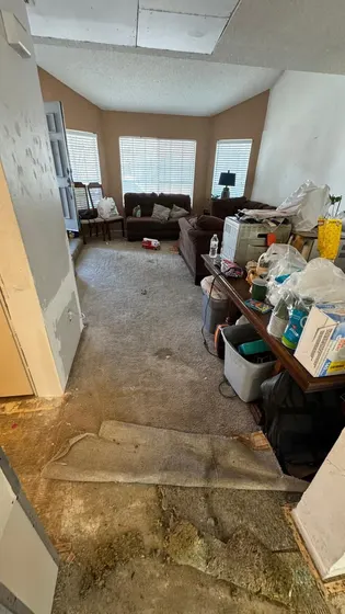 A large empty living room with hardwood floors and a fireplace.